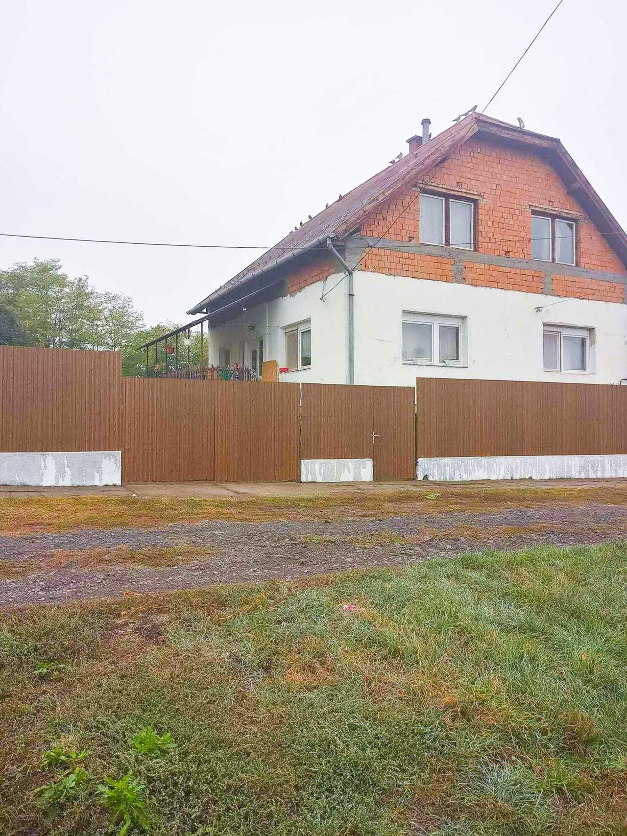 Barna fahatású trapézlemez kerítés családi háznál