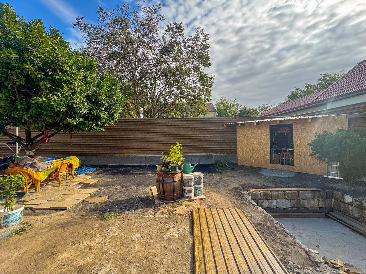 Fahatású trapézlemez kerítés udvarban műhelyépülettel