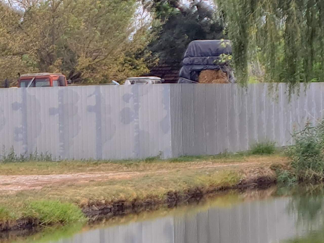 Fehér trapézlemez kerítés tanyaudvarban