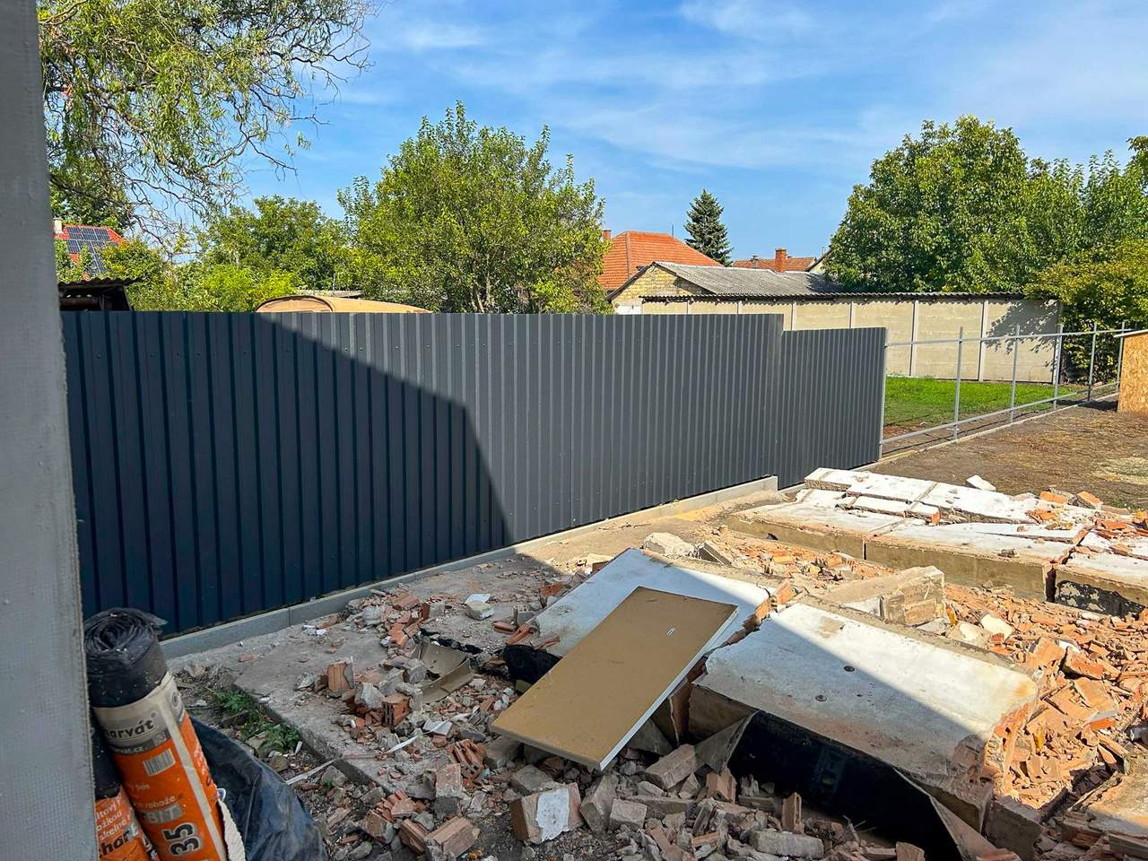 Szürke trapézlemez kerítés építkezési telken