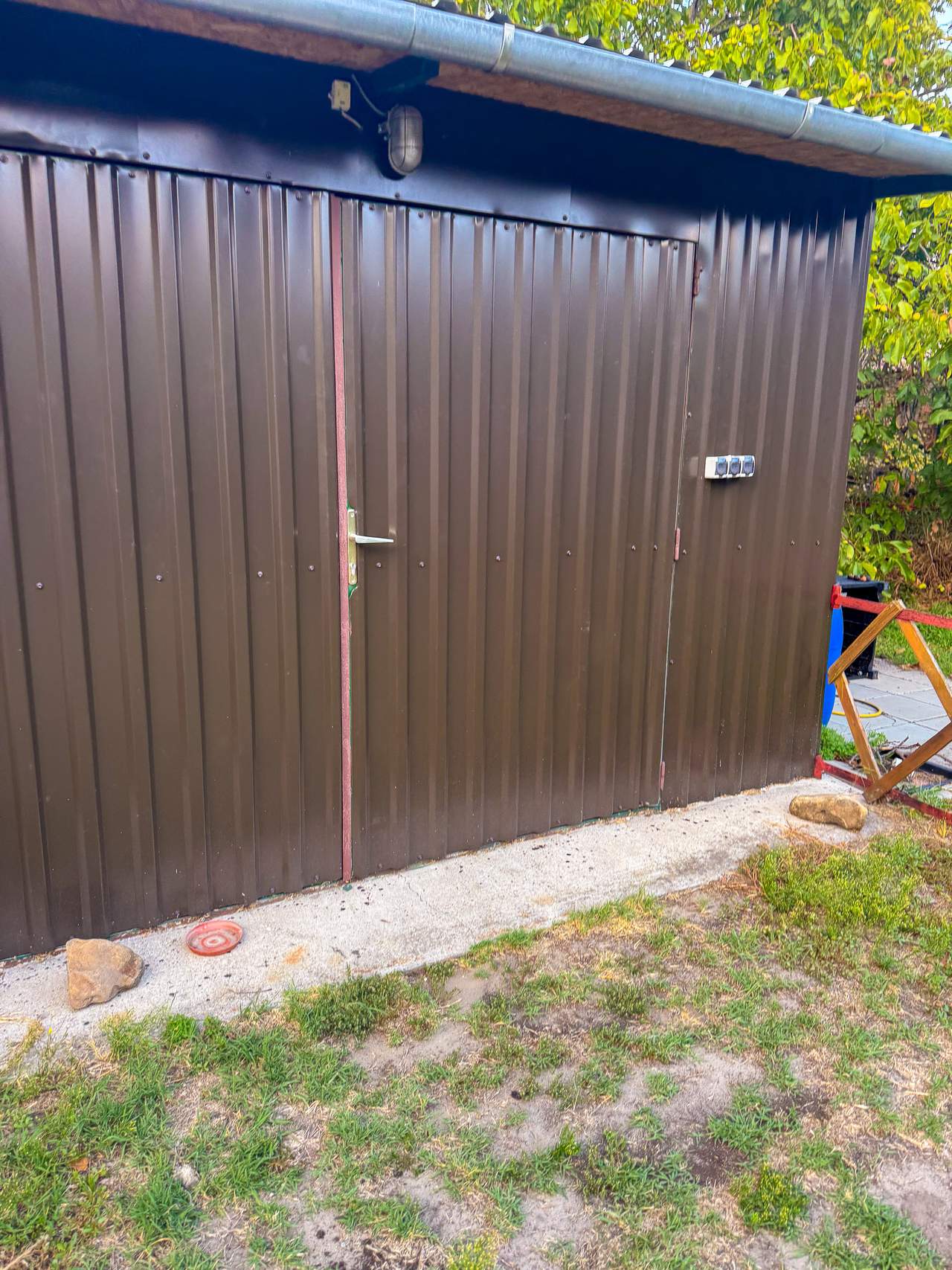 Barna trapézlemez szerszámtároló ajtóval